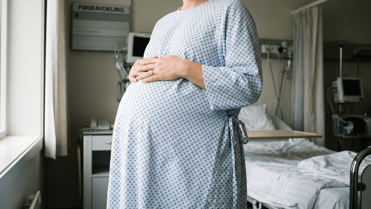 Gravid dame i sykehuskjortel på sykehuset